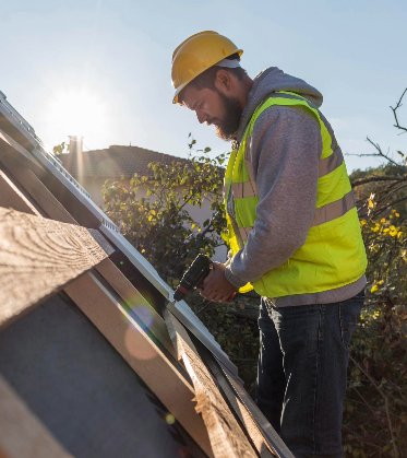 man working roof with drill min 1